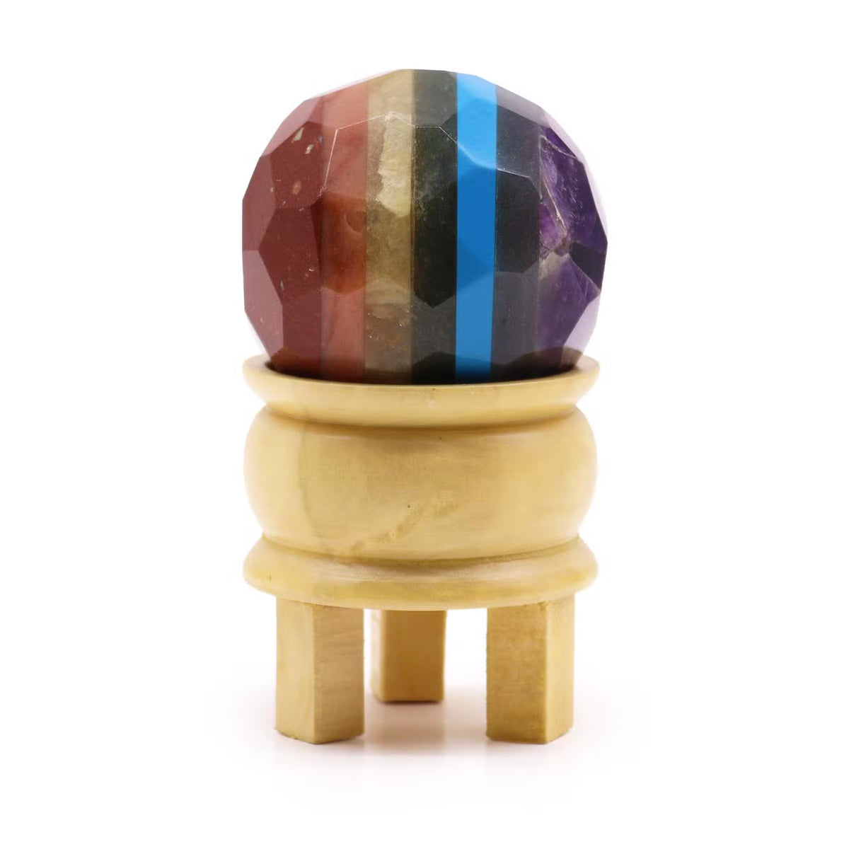 Sferă decorativă fațetată cu benzi multicolore, așezată pe suport din lemn deschis