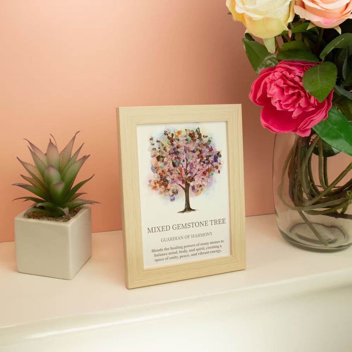 Tablou decorativ Arborele Armoniei cu pietre multicolore, așezat lângă o plantă și o vază cu flori